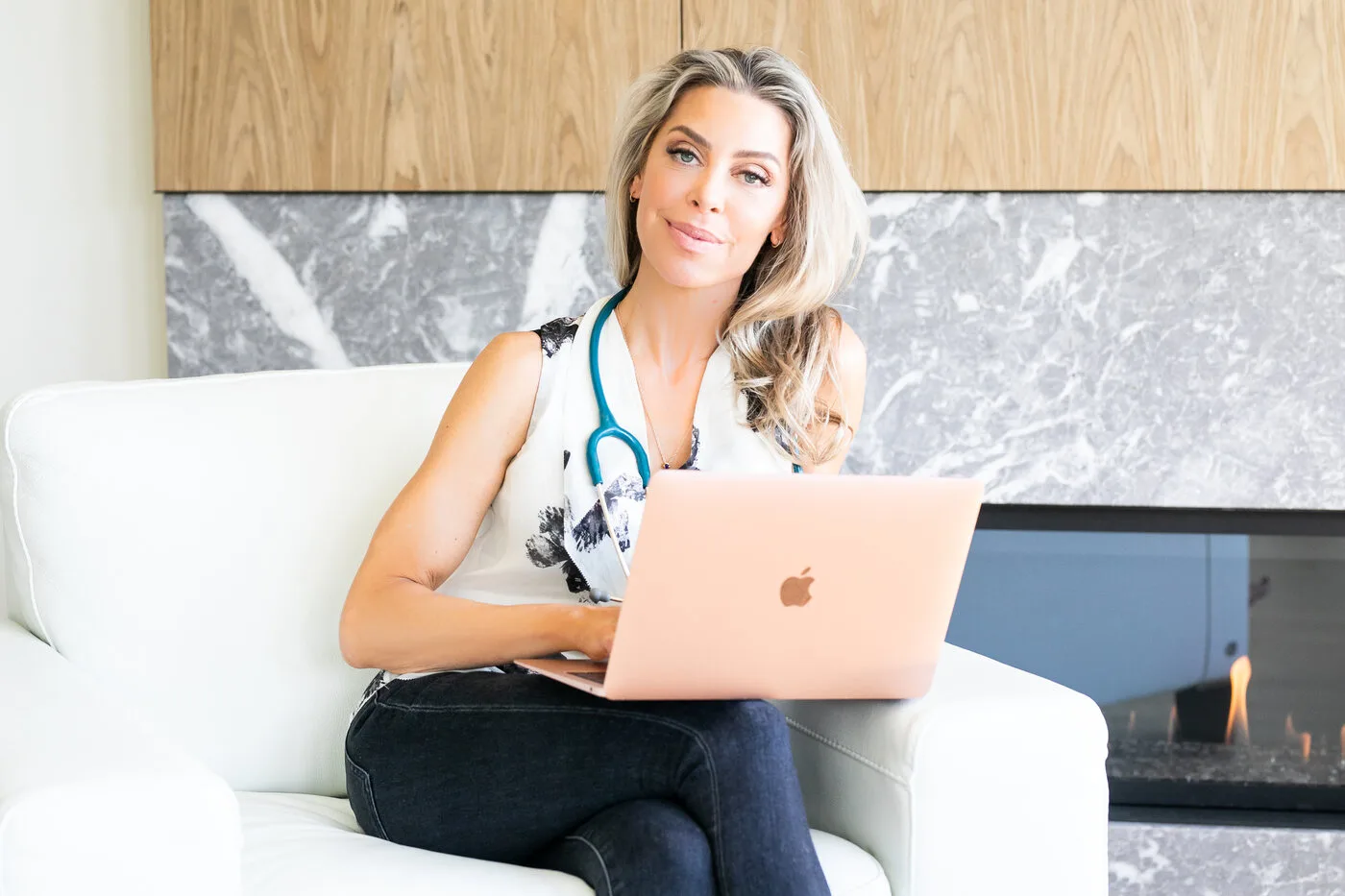 Dr. Jordana Aziz working on a laptop with a stethoscope